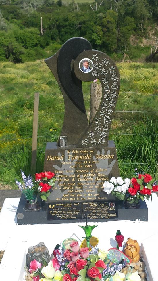 Custom headstone in irregular shape with carved hand motifs crafted from granite by Stoneworx - Memorials of Distinction in New Zealand.