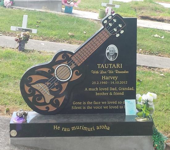 Custom headstone design with a carved guitar crafted from granite by Stoneworx - Memorials of Distinction in New Zealand.
