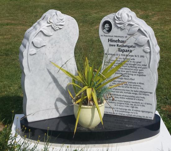 Custom double headstone in irregular shape with carved flowers  crafted from granite by Stoneworx - Memorials of Distinction in New Zealand.