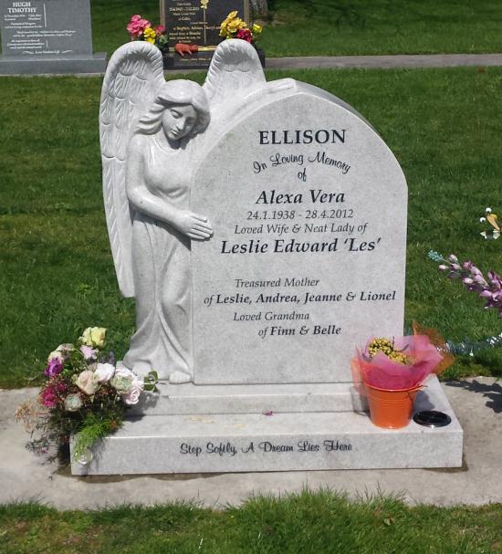 Custom headstone in a gothic arch shape with an angel cuddling the headstone crafted from granite by Stoneworx - Memorials of Distinction in New Zealand.