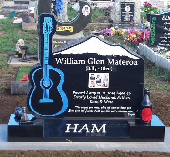 A custom shape headstone with guitar crafted from granite by Stoneworx - Memorials of Distinction in New Zealand.