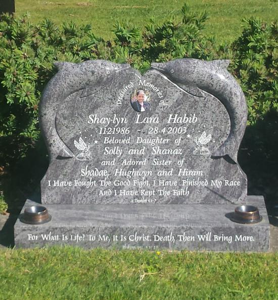 Custom headstone with two carved dolphins crafted from granite by Stoneworx - Memorials of Distinction in New Zealand.