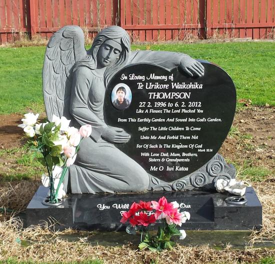 Custom headstone with an angel cuddling a heart crafted from granite by Stoneworx - Memorials of Distinction in New Zealand.