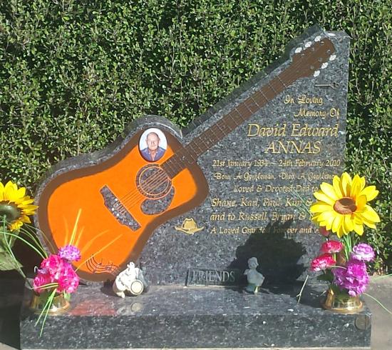 Custom headstone design with a carved guitar crafted from granite by Stoneworx - Memorials of Distinction in New Zealand.